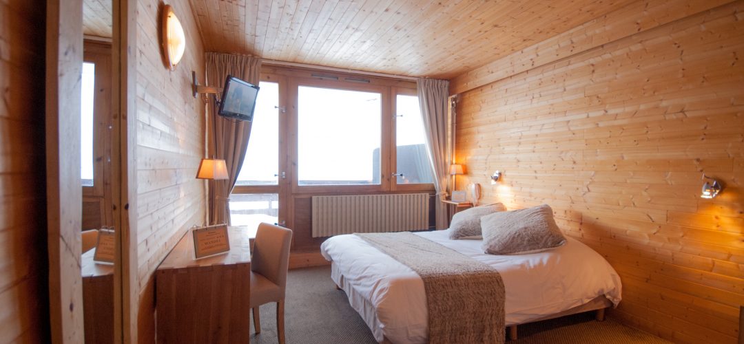 Photo d'une chambre bain de l'hôtel La Mandia, lit double, lit simple pour deux ou 3 personnes. Balcon avec vue sur les pistes de ski du Grand Tourmalet à La Mongie dans les Pyrénées.